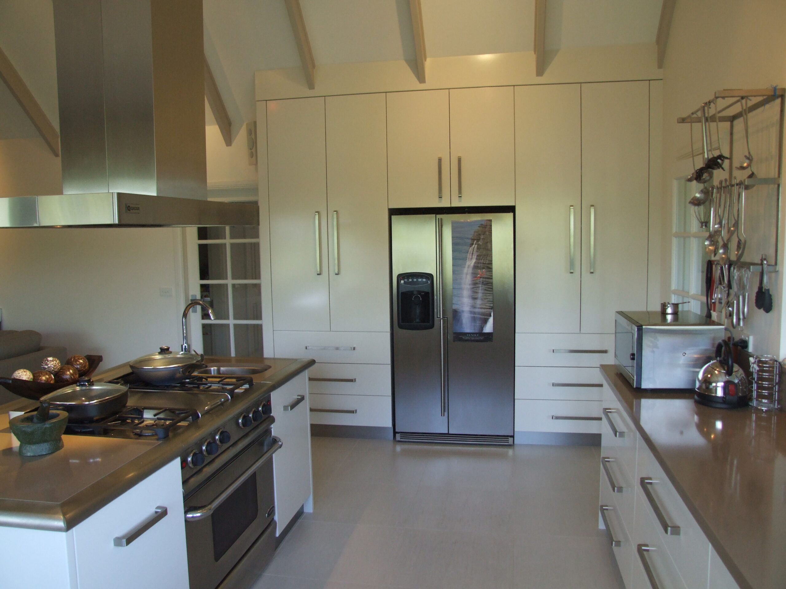 Chef's kitchen with custom white joinery and timber island bench — Brisbane Modern kitchen cabinetry with soft-close drawers — Robertson's Custom Cabinets Custom butler's pantry with full-height cabinetry — Gold Coast