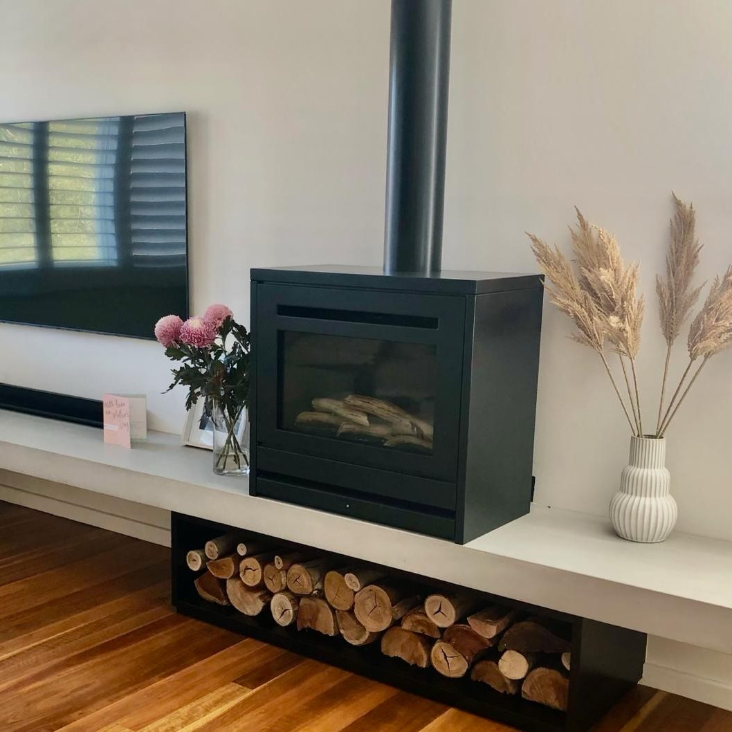 Modernized Living area with a simple floating shelf and wood storage area to meet practical space saving requirements for this family.