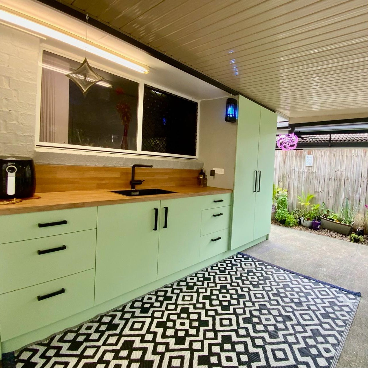 Basic outdoor storage zone with sink under awning, very handy for entertaining and gardeners bench.